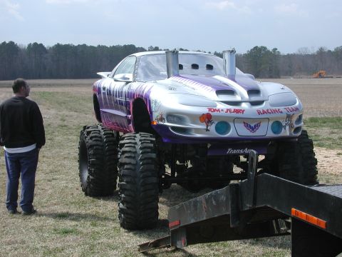 1985 Ford Bronco - This custom monster truck features a silver and purple paint scheme with Tom and Jerry racing team graphics.