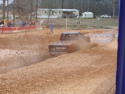 1985 Ford Bronco - Mud bog event with a truck navigating a muddy track.