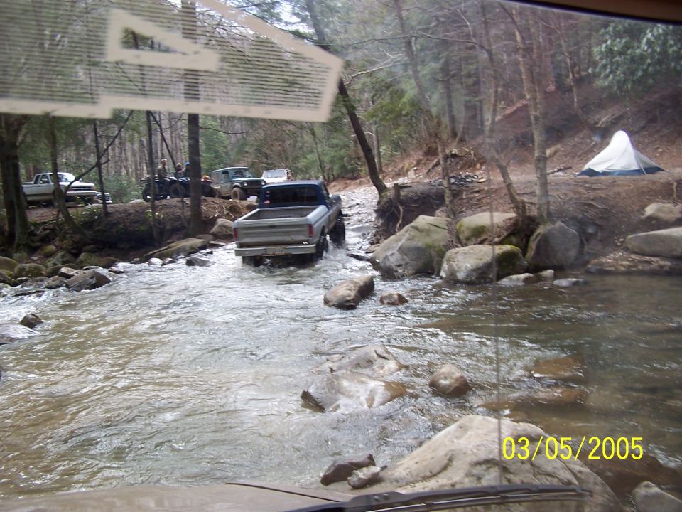 1979 Ford F-150 driving through stream, rear view, silver