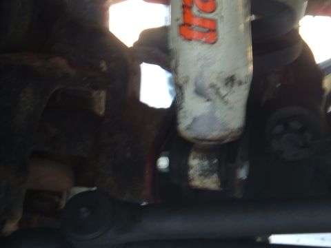 1978 Ford Bronco - A close-up view shows a shock absorber, a component of a vehicle's suspension system.
