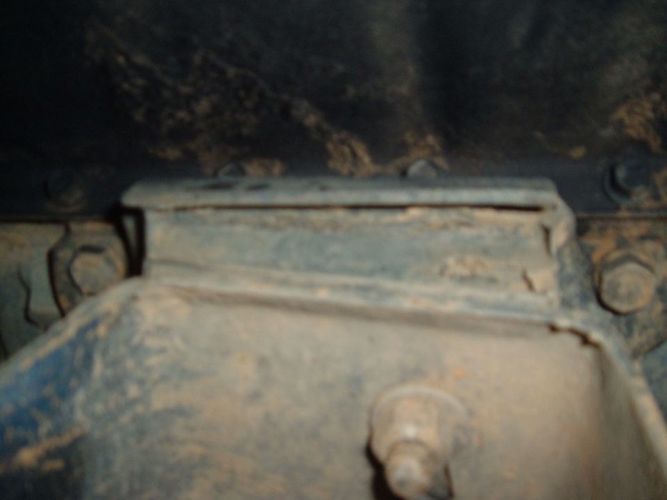 Close-up of a rusty metal frame mount with bolts