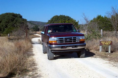 1996 Ford Bronco - This 1996 Ford Bronco, equipped with a body lift, navigates a dusty, rural road.