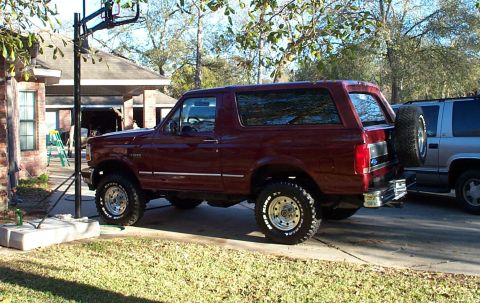 1996 Ford Bronco - This maroon 1996 Ford Bronco features a body lift and a spare tire mounted on the rear tailgate.