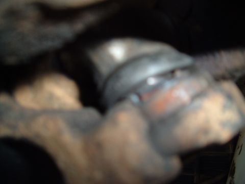 1978 Ford Bronco - A blurry, close-up view of a vehicle's undercarriage component, possibly part of the suspension system.