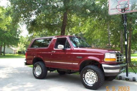 1996 Ford Bronco - Dark red two-door Ford Bronco full-size SUV with a matching removable hardtop, silver lower body accent, chrome wheels and chunky all-terra…