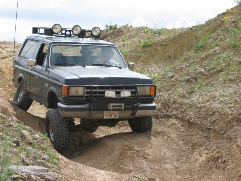 1988 Ford Bronco - This 1987 Ford Bronco is tackling a challenging off-road course on a sunny day.