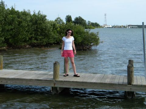 1995 Nissan Frontier - A woman stands on a wooden pier with trees and water in the background.