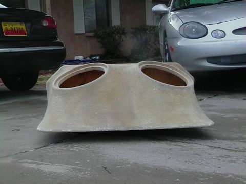 1999 Ford Taurus - A custom fiberglass speaker enclosure sits on a driveway between two cars.