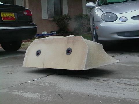 1999 Ford Taurus - Fiberglass body kit part sits on a driveway between two cars.