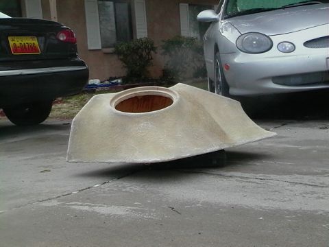 1999 Ford Taurus - A fiberglass part sits on a driveway next to a silver 1998 Ford Taurus.