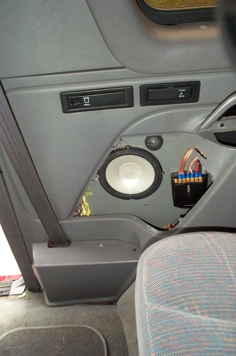 1996 Ford Bronco - Interior view of a gray rear side panel with the speaker grille removed, exposing an aftermarket component woofer, a separate tweeter and a…