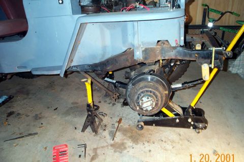 1954 Jeep Wrangler - Jeep Wrangler undergoing brake and suspension work in a garage.