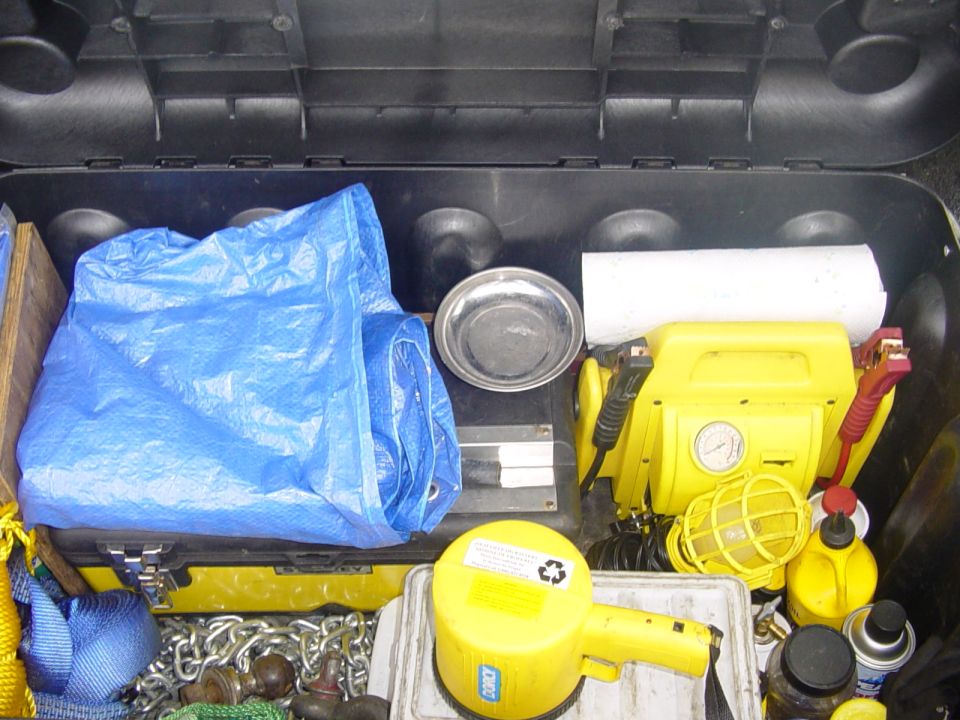 Spot light, Tarps, Magnetic bolt tray, 12v work light, Chain, Bow shackle, strap for towing, short strap for snatching, trailer ball, plywood for hi-lift, tool box, 2 smaller bins with spare parts