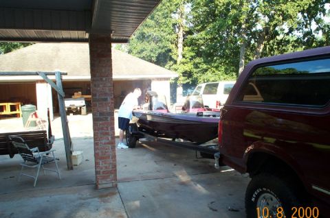 1996 Ford Bronco - A maroon 1996 Ford Bronco is parked in a driveway, hitched to a boat on a trailer.