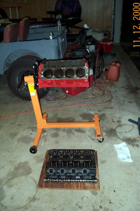 1996 Ford Bronco - Engine block and cylinder heads are laid out on the floor, possibly for rebuild or inspection.