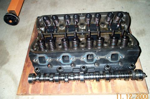 1996 Ford Bronco - Engine cylinder head and camshaft components are laid out on a wooden surface, likely for an engine buildup or repair.