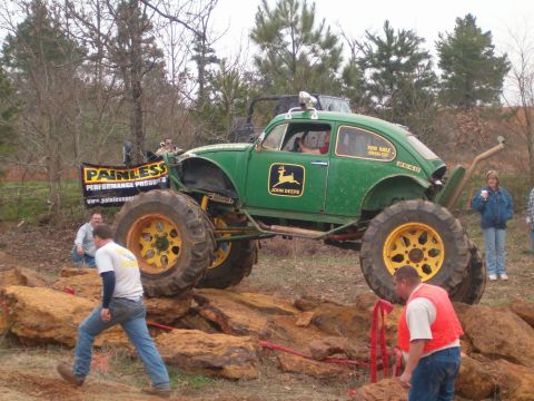 1996 Ford Bronco - This heavily modified Volkswagen Beetle, adorned with John Deere branding, tackles a rocky obstacle course.