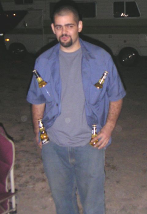 1988 Ford Bronco - A man stands outdoors with several beer bottles placed in his shirt and pockets.