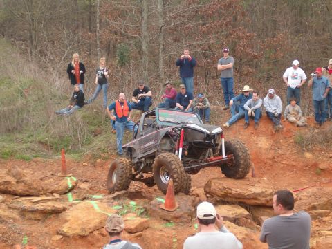 1996 Ford Bronco - Spectators watch an off-road vehicle navigate a rocky course.