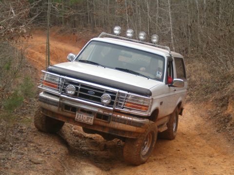 1996 Ford Bronco - This 1996 Ford Bronco navigates a muddy off-road trail with auxiliary lights mounted on the roof.