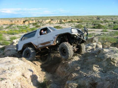 1988 Ford Bronco - This heavily modified SUV navigates a challenging off-road course with steep inclines and rocky obstacles.