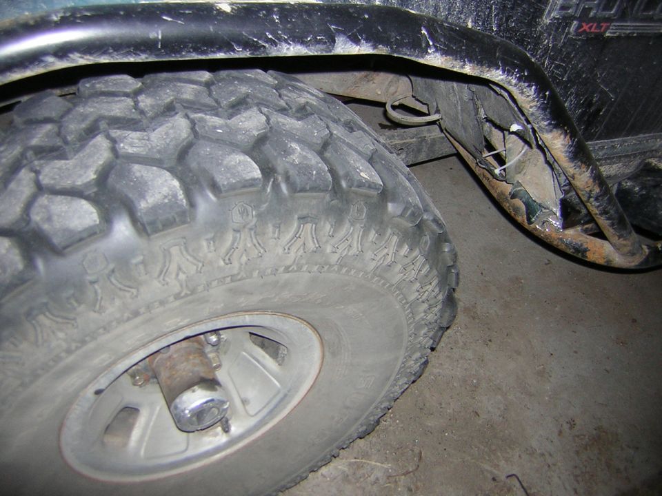 1995 Ford Bronco rear tire and damaged fender flare with exposed metal