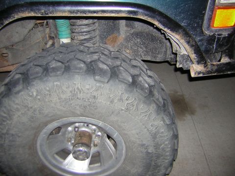 1995 Ford Bronco - Close-up of a vehicle's wheel well and tire, showing off-road modifications.
