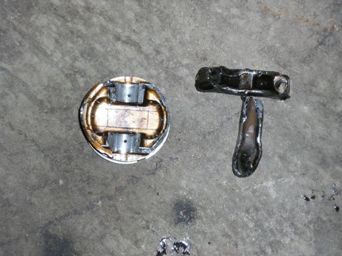1990 Ford Probe - Close-up of a piston and connecting rod, likely automotive engine components.