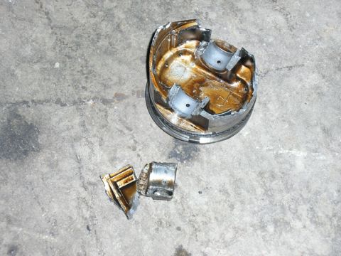 1990 Ford Probe - A close-up view of a worn engine part, likely a distributor assembly, resting on a textured ground.
