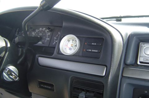 1993 Ford Bronco - The interior of a vehicle shows the dashboard with various controls and gauges.