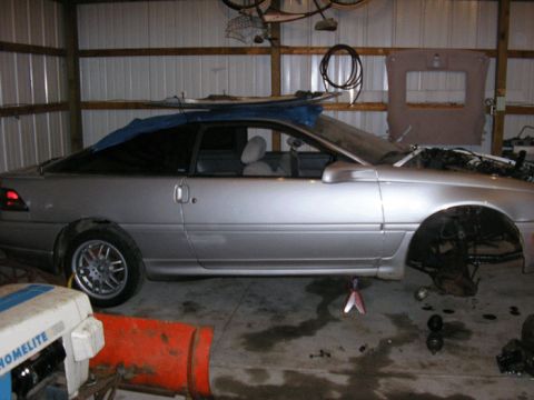 1990 Ford Probe - Side view of a silver 1990 Ford Probe coupe in a garage setting.