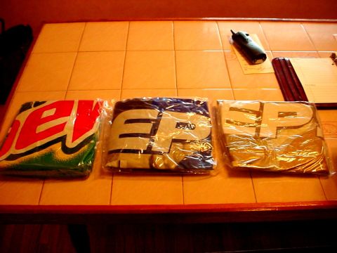 1973 Ford Ranchero - Three t-shirts are laid out on a tiled surface, one with a Mountain Dew logo and two with large white lettering.