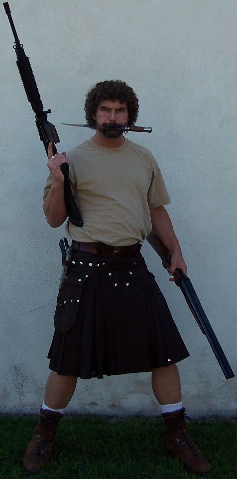 1990 Ford Bronco - Man poses with firearms and a knife in his mouth, wearing a kilt.