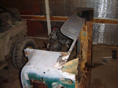 1992 Ford Bronco - A disassembled Jeep CJ-6 is in a workshop, with its engine and body panels exposed. Another vehicle is partially visible.