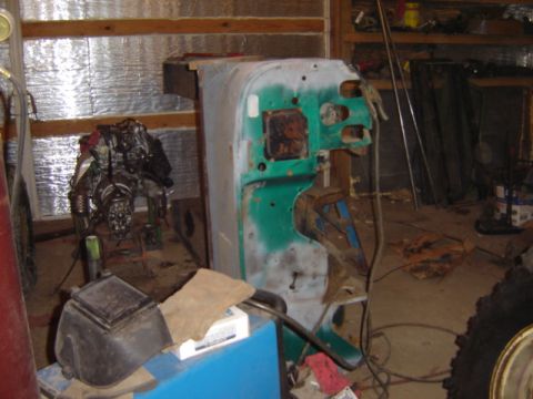 1992 Ford Bronco - A disassembled vehicle body panel and engine are visible in a cluttered workshop environment.