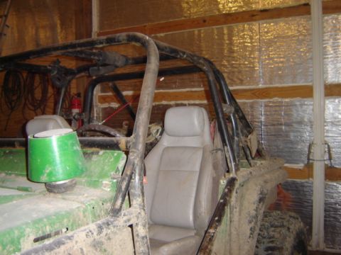 1992 Ford Bronco - This off-road buggy is covered in mud and parked inside a structure with insulated walls.
