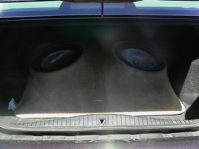 Car trunk interior showing a custom dual subwoofer enclosure