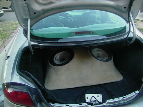 1999 Ford Taurus - The open trunk of a silver 1999 Ford Taurus reveals a custom dual-subwoofer enclosure.