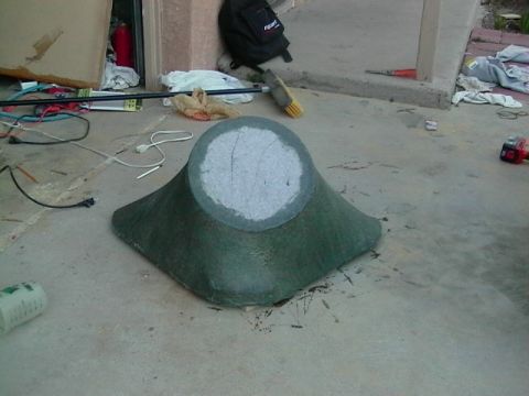 1999 Ford Taurus - A green fiberglass part sits on a concrete surface, with various tools and debris scattered around.