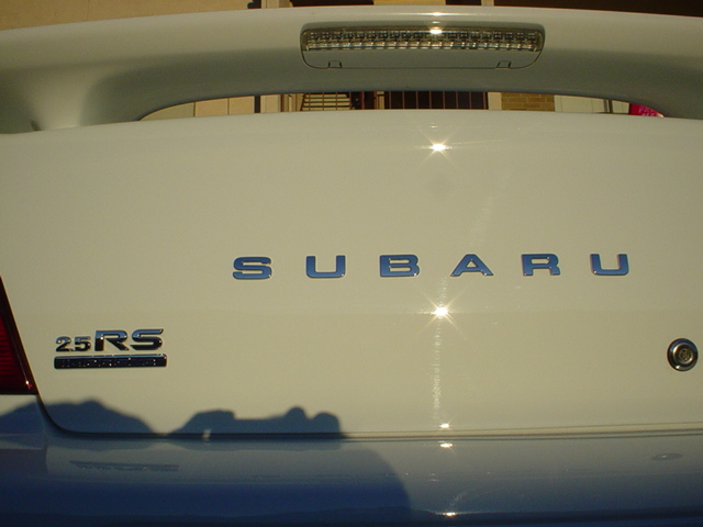 White Subaru 2.5RS trunk lid with chrome badges and a spoiler brake light