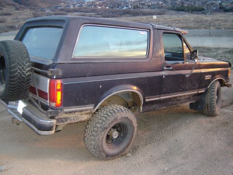 1991 Ford Bronco - This 1991 Ford Bronco is parked on a dirt road with hills in the background.