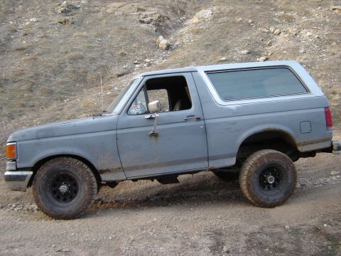 1991 Ford Bronco - This Ford Bronco is parked on a dirt road with a rocky hillside in the background.