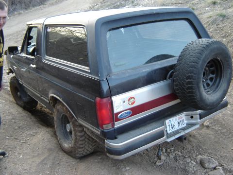 1991 Ford Bronco - This black Ford Bronco has a spare tire mounted on the rear and appears to be lifted for off-road use.