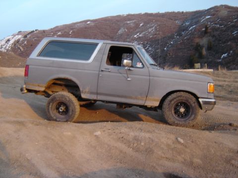 1991 Ford Bronco - This 1991 Ford Bronco is shown on an off-road trail with a mountainous backdrop.