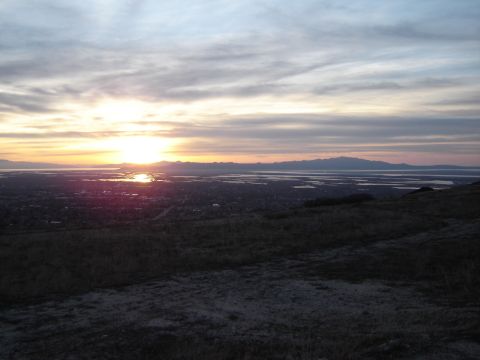1991 Ford Bronco - A scenic view of a sunset casting a warm glow over a vast landscape of water and mountains.