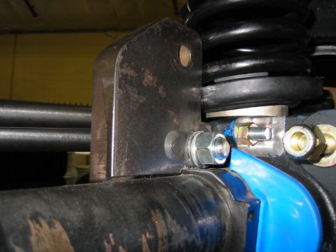 1992 Ford Bronco - A close-up view of a vehicle's suspension system, focusing on a metal bracket and axle.