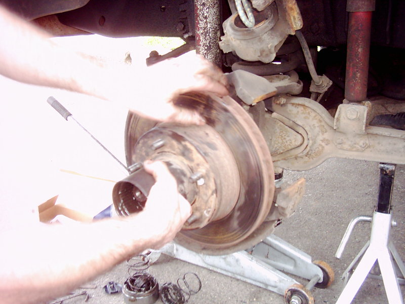 Brake rotor assembly being worked on, showing suspension components