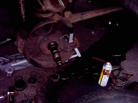 1978 Ford Bronco - A close-up view of a disassembled brake rotor and hub assembly, with various parts and tools scattered around.