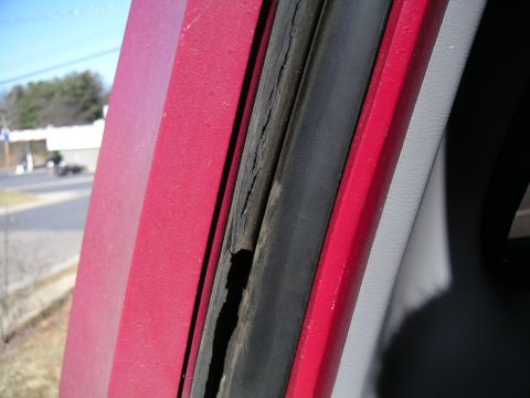 1994 Ford Bronco - The rubber seal around the door frame of the vehicle is visibly deteriorated and cracked.