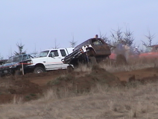 1994 Ford Explorer navigating a muddy hill, with other off-road vehicles nearby
